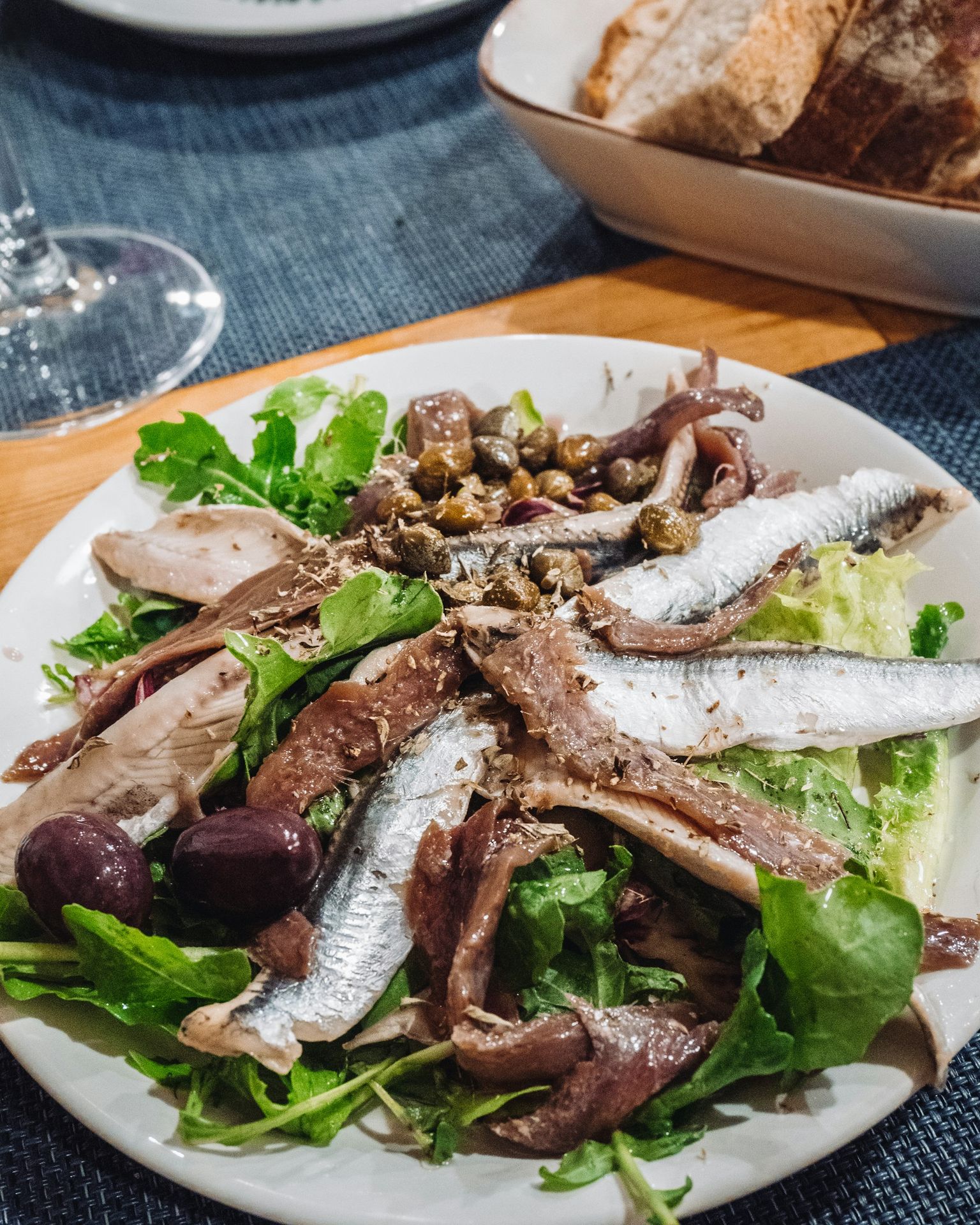 a white plate topped with a salad covered in fish