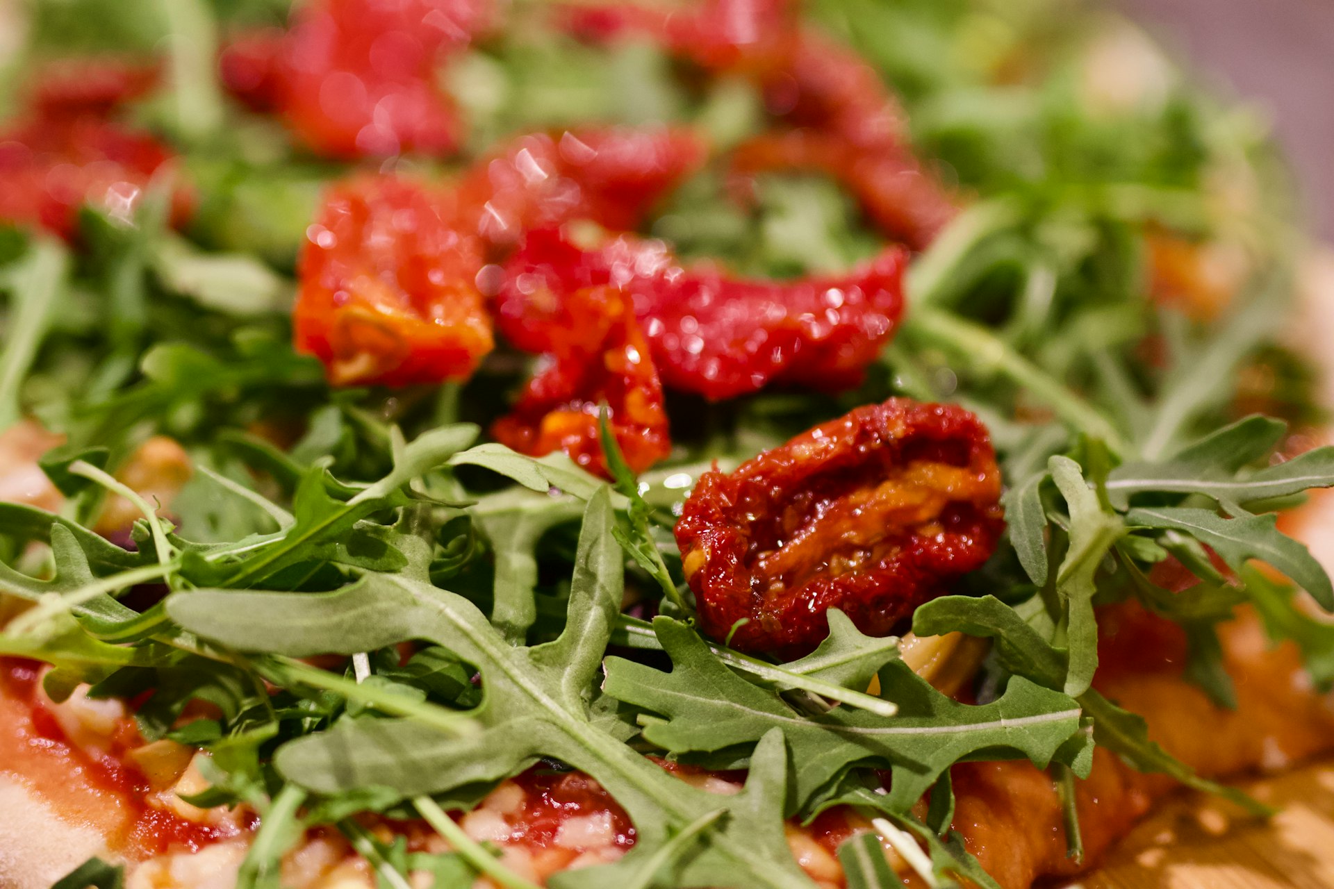 a pizza topped with lots of greens and toppings