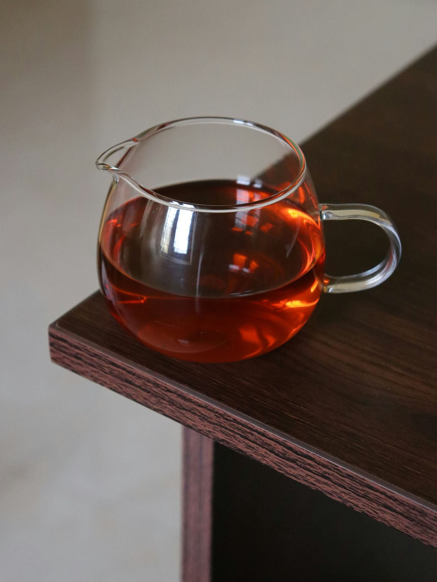 a glass pitcher of tea sitting on top of a wooden table