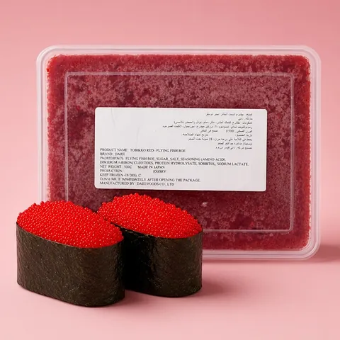 Red tobiko gunkan maki, two pieces side by side beside a Daiei red tobiko tray