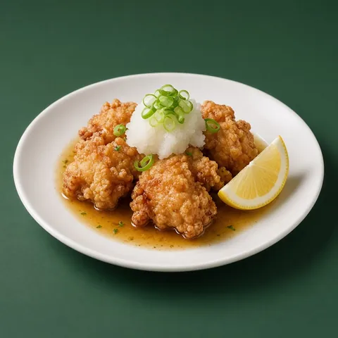 Chicken karaage topped with grated daikon and spring onion in a pool of ponzu, with a lemon wedge