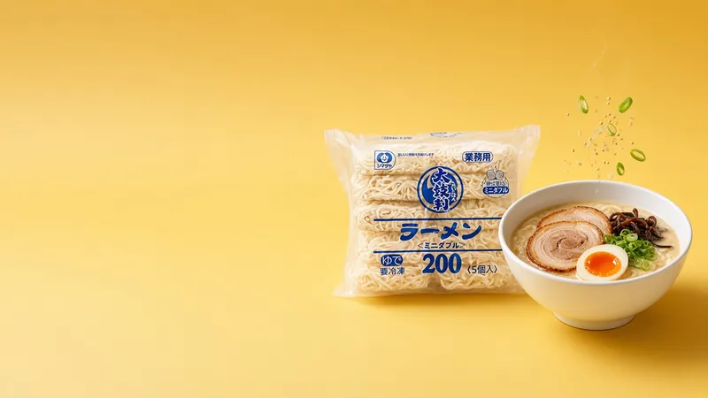 Bowl of tonkotsu ramen with chashu and soft egg beside a Shimadaya ramen bag