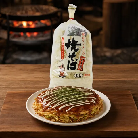 Hiroshima-style okonomiyaki with a crisp noodle layer in front of a Tokyo yakisoba pack