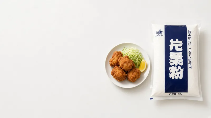 Golden karaage chicken with lemon and shredded cabbage on a white plate beside a Maruboshi potato starch bag