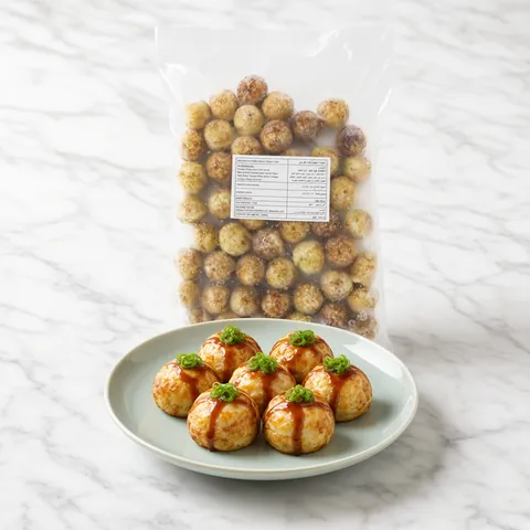 Takoyaki with a drizzle of sauce and spring onion on a celadon plate in front of a bag of GGFT frozen takoyaki