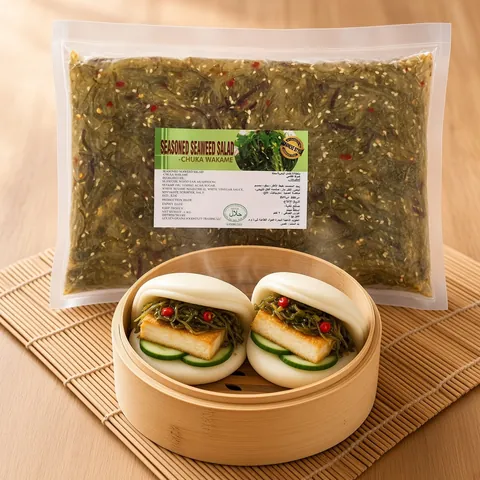 Steamed bao buns with crispy tofu, cucumber and spicy seaweed salad in a bamboo steamer in front of a GGFT spicy chuka wakame pack