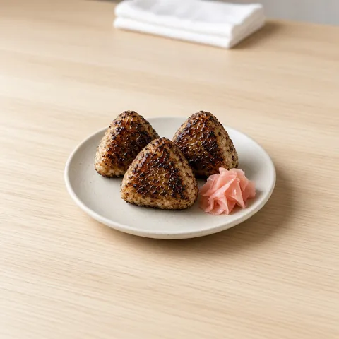 Three grilled yaki onigiri brushed with a sweet glaze with pickled ginger