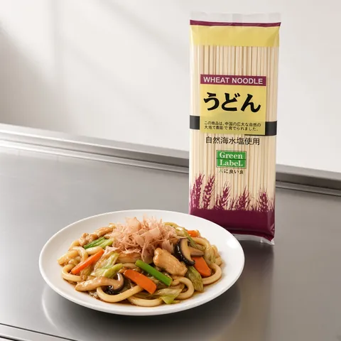 Yaki udon stir-fried with chicken and vegetables in front of a Green Label udon pack