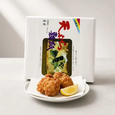 Karaage fried chicken on white tempura paper in front of a QING tempura paper pack