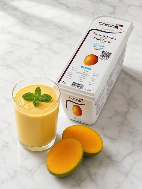 Tumbler of mango lassi with a mint sprig beside a tub of Boiron Mango Fruit Puree