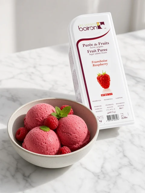 Scoops of raspberry sorbet in a bowl beside a tub of Boiron Raspberry Fruit Puree