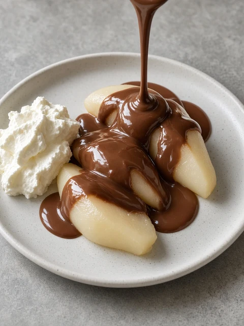 Pear halves with warm chocolate sauce and cream