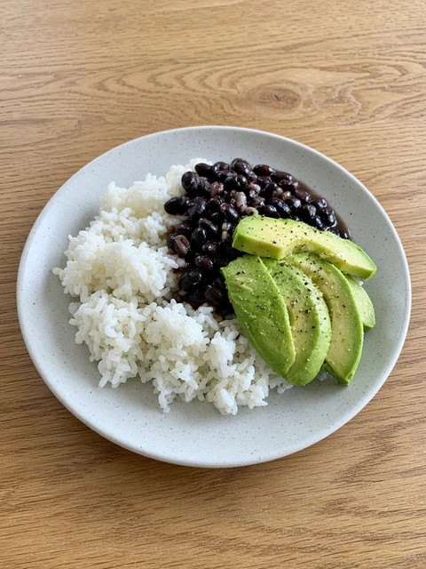 Plate of rice with black beans and avocado slices